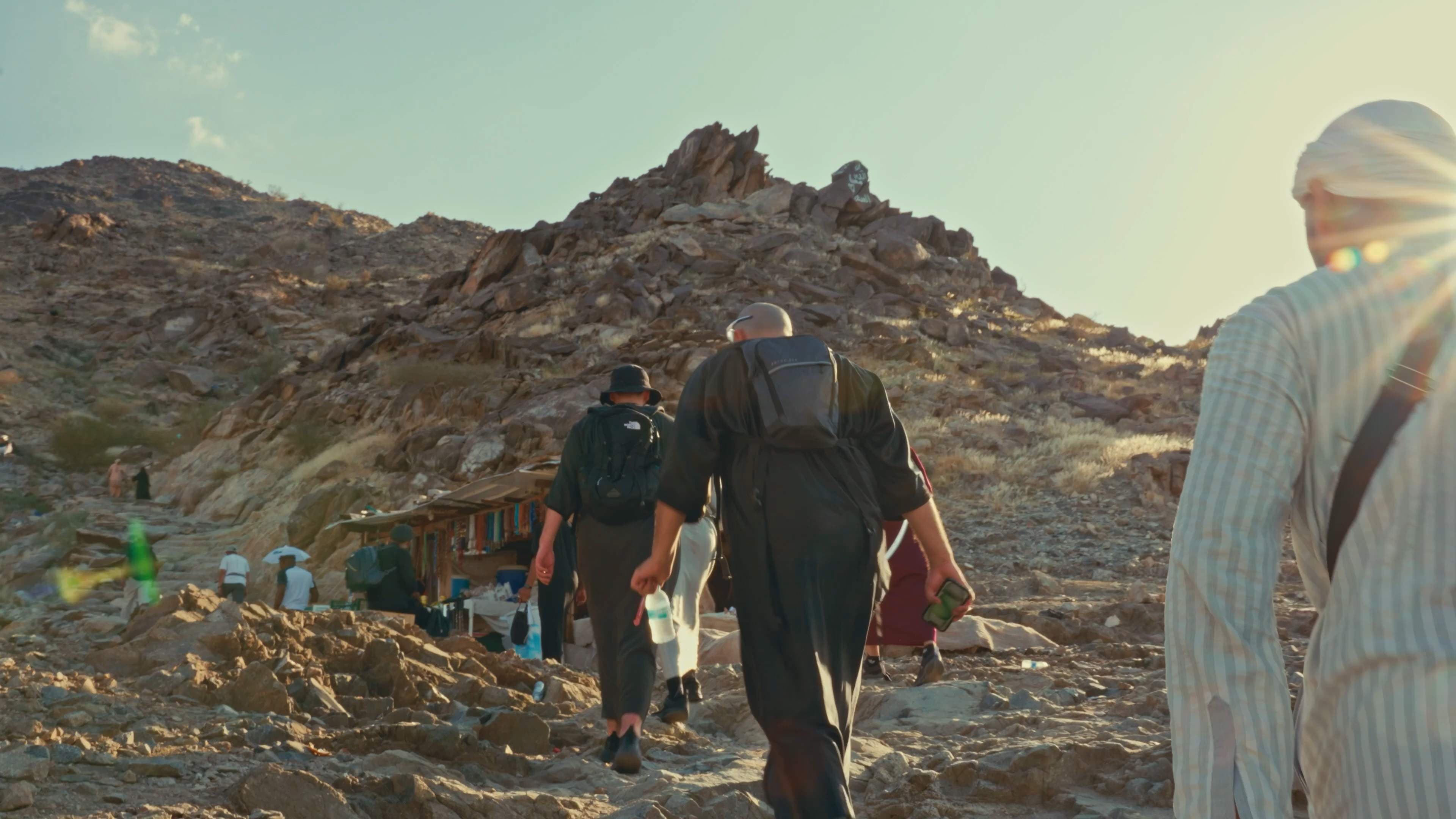 Travelers walking along a rocky mountain path